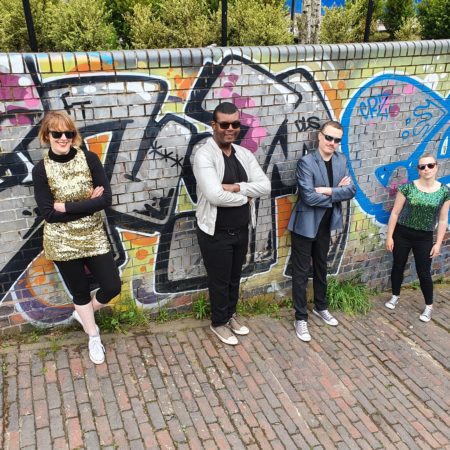 4 dancers leaning against a wall